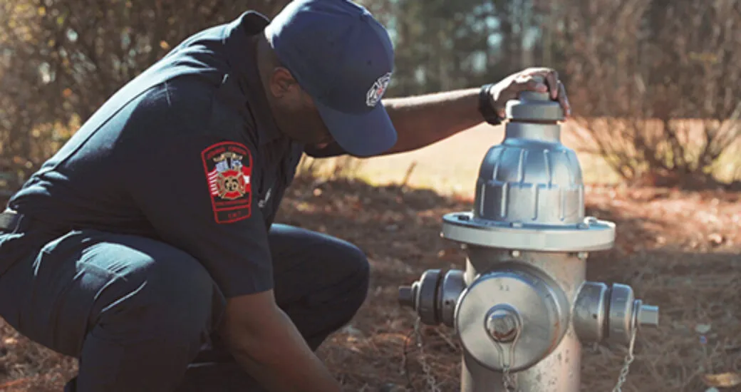 Firefighter inspecting a fire hydrant